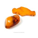A brooch formed from a slice of Baltic amber, together with a polished Baltic amber brooch, 25g gros