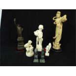 A spelter figure of the Statue of Liberty, 32cm high, together with a pair of carved stone figures