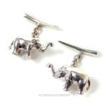 A pair of heavy silver cufflinks in the form of elephants.