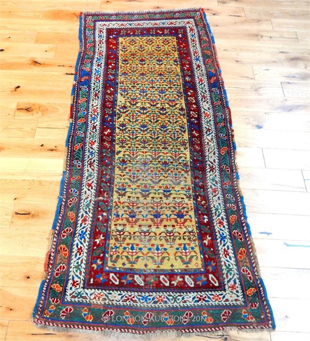 A hand made Persian runner with repeating motifs of a yellow field