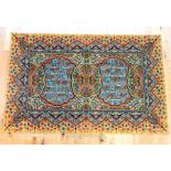 An Arabic wall hanging decorated with script in two reserves, surrounded by an ornate border