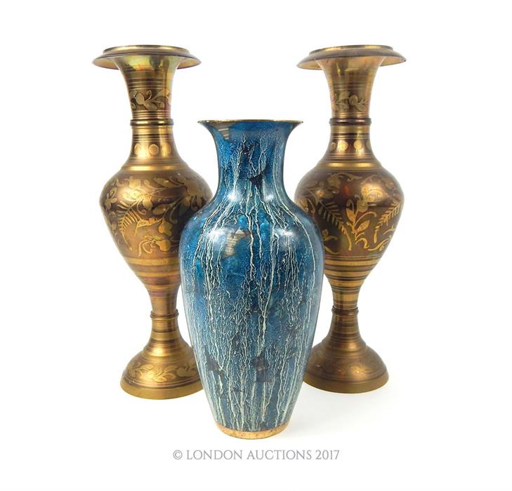 A pair of Indian brass vases decorated with peacocks amongst foliage and another