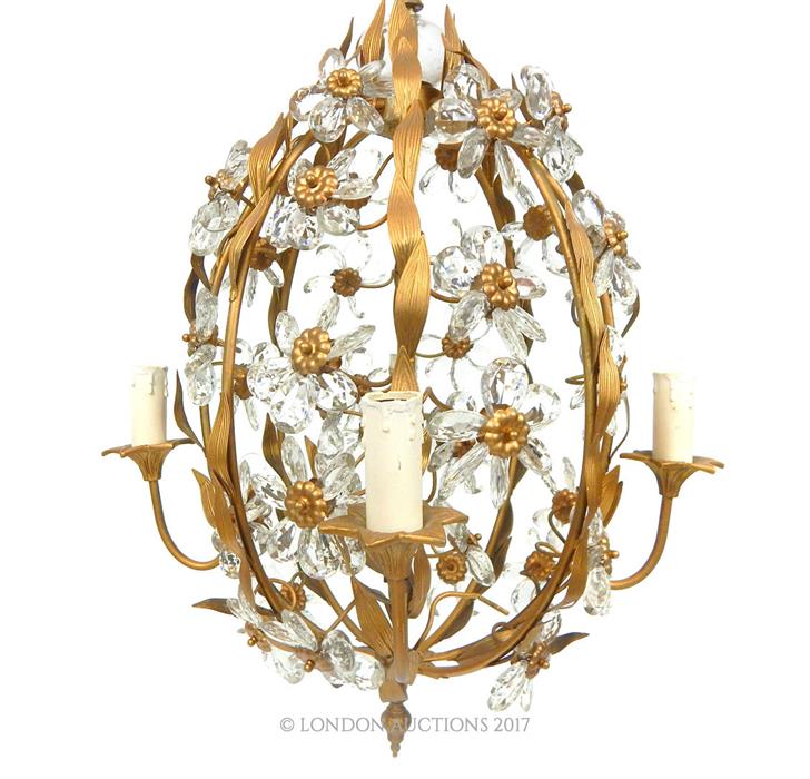 A gilded cage form chandelier, having four branches with four candles, decorated with lustres