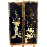 A pair of Chinese black lacquered panels, inlaid with mother of pearl in relief