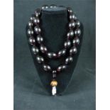 A substantial Chinese cherry amber necklace; 627g.