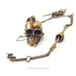 A brass skull shaped vesta case and watch chain.