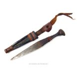 A small handmade ethnic dagger in a leather sheath