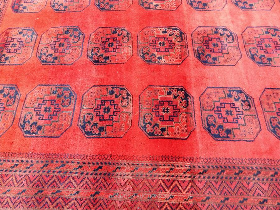 A Turkoman carpet, with large elephant foot motifs on a red field, surrounded by running borders, - Image 2 of 3