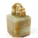 A Chinese jade seal with four character mark to its base; gilt paint decoration; 7cm high.