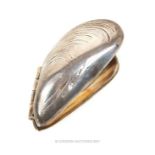 A white metal, hinged, mussel eater in the form of an open mussel shell