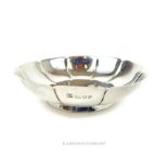 A sterling silver dish with the rim in the form of a ten petalled flower head