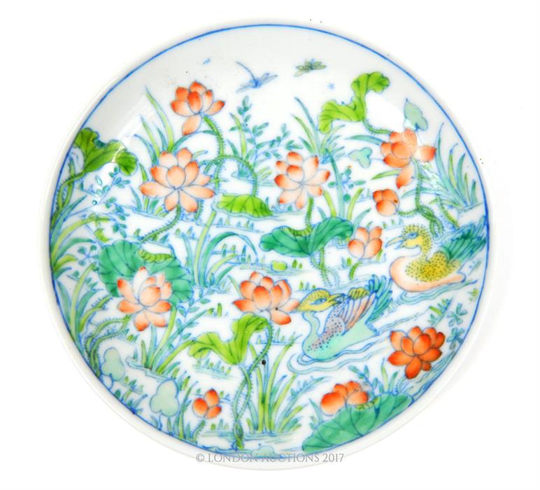 A Chinese porcelain dish, hand painted in the doucai palette with ducks swimming between lilies