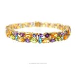 A 9 ct yellow gold, blue topaz, amethyst, citrine, pink tourmaline and sapphire tennis bracelet