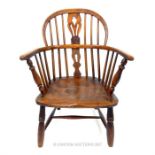 An early 19th century Windsor armchair, having a pierced splat and spindle back