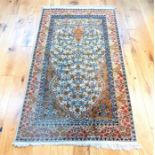 An pure silk Qum rug, with floral designs on an ivory field