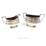 A hallmarked sterling silver milk jug and matching twin handled sugar bowl, assayed in Sheffield