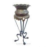 A late Victorian Arts and Crafts copper jardiniere and stand