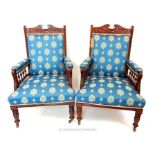 A pair of Edwardian show frame mahogany armchairs with blue upholstery.