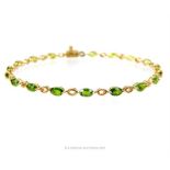 A 9 ct yellow gold, claw-set demantoid garnet, tennis bracelet