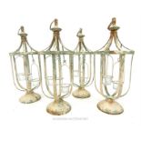 A set of four painted and distressed metal tea light holders of lantern form