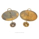 A pair of bronze circular occasional tables with hoop handles, raised on a circular step down base
