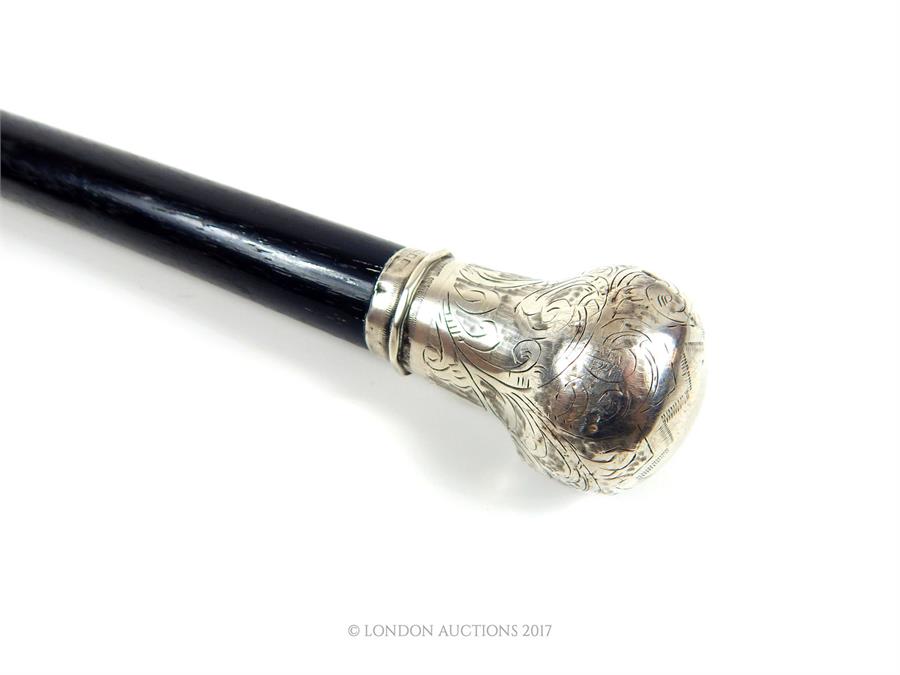 An Edwardian, ebonised walking cane with a sterling silver top