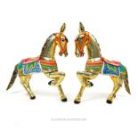 A pair of Indian hand painted and silvered carved wooden figures of horses