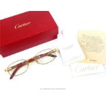 A pair of Cartier gold plated and bubinga wood spectacles, made in France, in original box