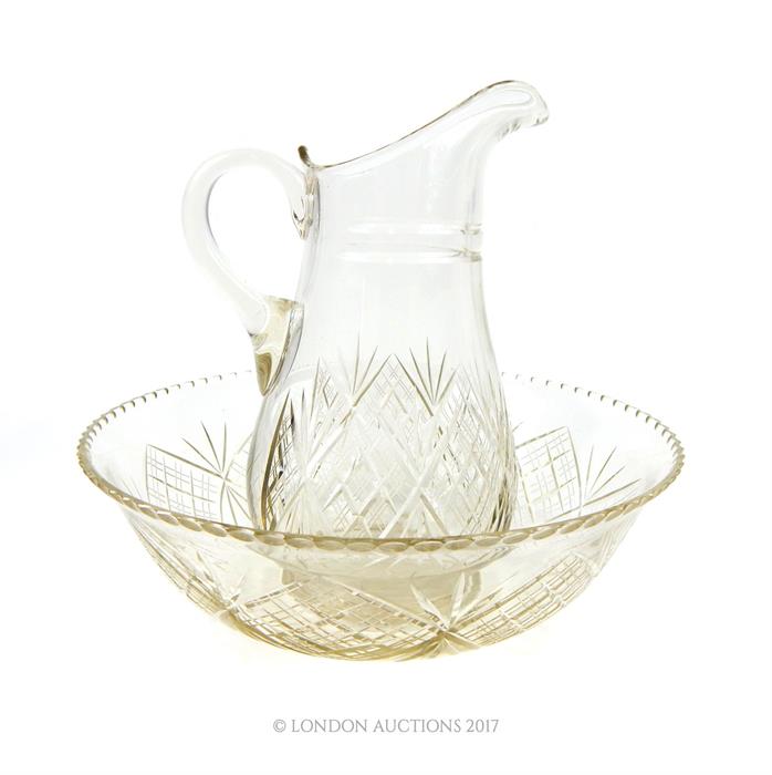 An Edwardian hand blown cut crystal water jug and basin set