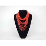 A coral necklace, made from several long strands of small coral beads