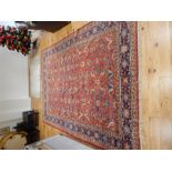 A large Persian Kashan carpet, having floral designs on a red field