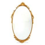 A gilt wall mirror, having an oval bevelled plate, the frame adorned with acanthus leaves