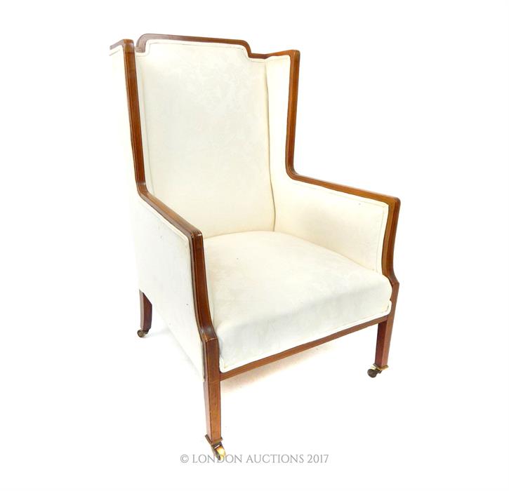 An Edwardian mahogany wing armchair with walnut frame and boxwood inlays and cream upholstery. - Image 2 of 2