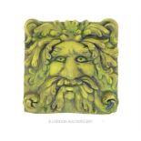 A green painted reconstituted stone plaque depicting the 'Green Man'