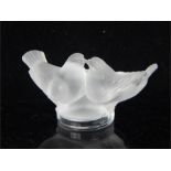 A Lalique figural group of two birds, signed to the side of its base; 7.5cm wide.