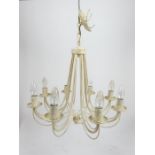 A cream painted and distressed metal eight branch chandelier