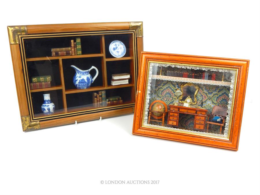 Two framed dioramas, one depicting a Victorian study with globe