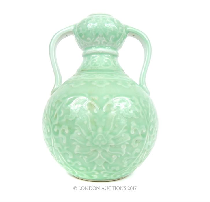 A large, twin-handled, celadon-glazed vase