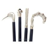 Four, black, ebonised, walking sticks with various white metal handles