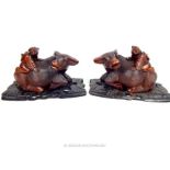 A pair of carved Chinese hardwood figural group of figures seated on water buffalo