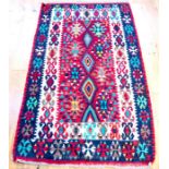 A Turkish kelim rug, with lozenges on a red field