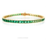An elegant, 10 ct yellow gold tennis bracelet set with green sapphires