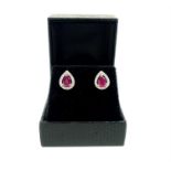 A pair of striking, 18 ct white gold, pear-drop ruby and diamond stud earrings
