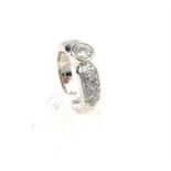 A contemporary,18 ct white gold, diamond solitaire ring with diamond-set shoulders