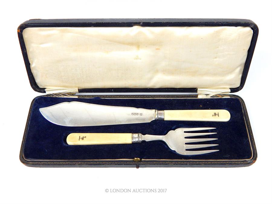 A George V cased pair of sterling silver fish servers with ivory handles