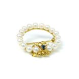 A 9 ct yellow gold, circular brooch set with a sapphire and cultured pearls