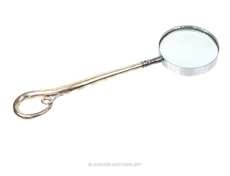 A magnifying glass with a sterling silver handle