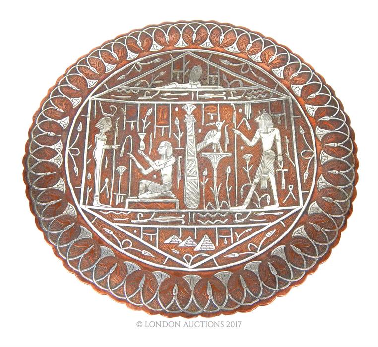 A circular copper dish, inlaid with silver