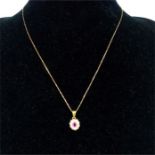 An 18 ct yellow gold ruby and diamond pendant on a 9 ct, yellow gold chain