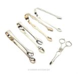 A collection of five sterling silver sugar tongs